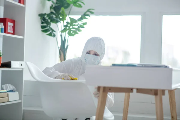 Persona en ropa de trabajo protectora desinfectando la habitación — Foto de Stock