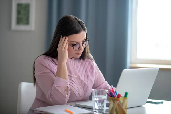 Nő rózsaszín blúzban szemüvegben stresszesnek tűnik. — Stock Fotó