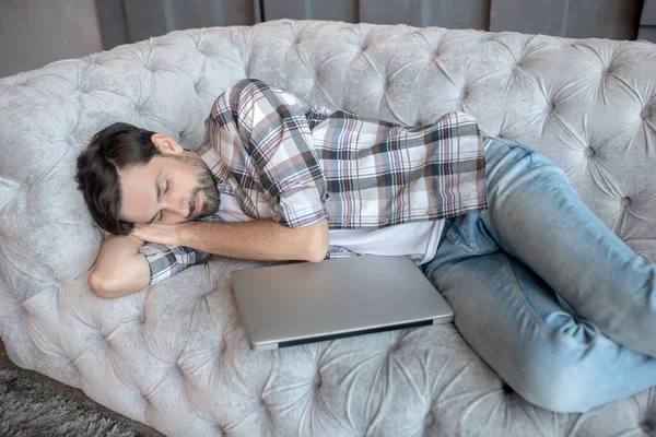 Joven cansado durmiendo en casa en el sofá . — Foto de Stock