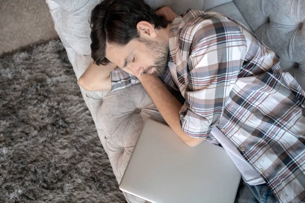 Vousatý muž v kostkované košili spí doma. — Stock fotografie