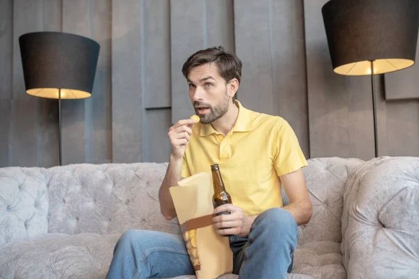 Interested man with open mouth with beer and chips. — Stock Photo, Image