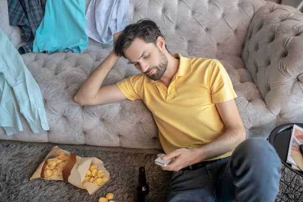 Hombre guapo sentado solo en el suelo aburrido . — Foto de Stock