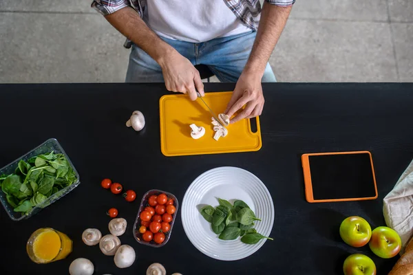 Male hands slicing porcini mushrooms on a cutting board. — Stock Photo, Image