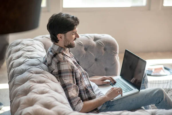 Man with laptop looking smiling at the screen. — Stock Photo, Image
