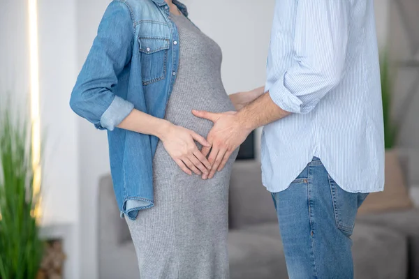 Imagen de cerca de manos masculinas tocando el abdomen embarazada — Foto de Stock