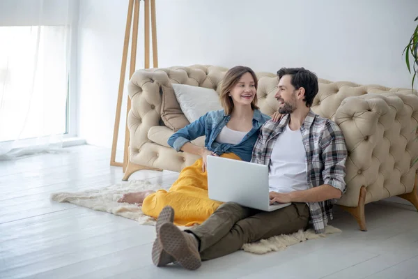 Feliz casal sentado no chão em casa — Fotografia de Stock