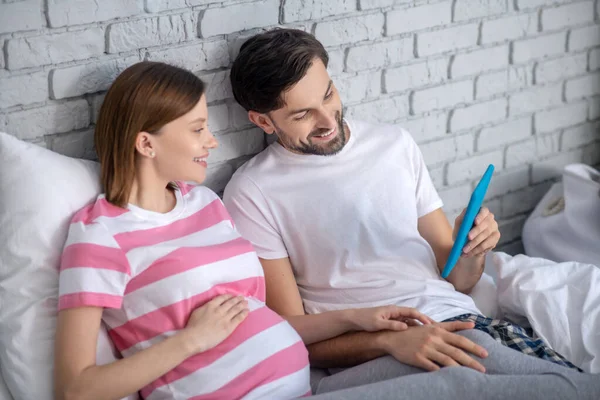 임신 한 여성 과 남편 이 인터넷 서핑을 하고 인터넷 검색을 하는 모습 — 스톡 사진