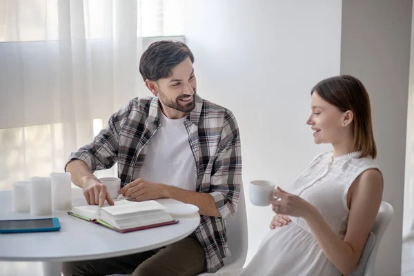 Homme brun et sa femme enceinte assis dans la cuisine et se sentant bien — Photo