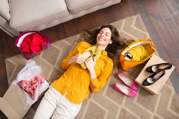 Smiling young girl holding new shoes and feeling happy — Stock Photo, Image