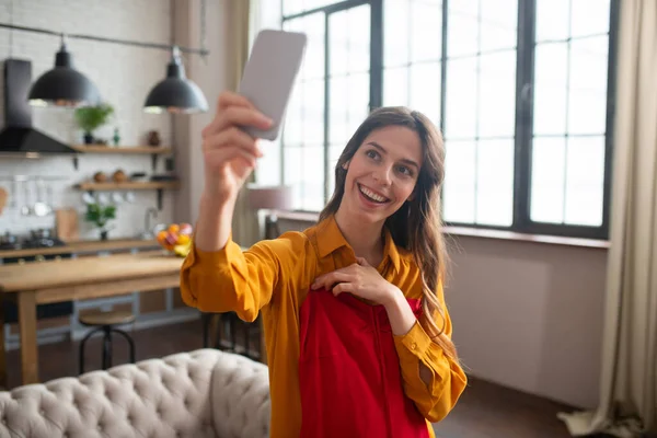 Sonriente chica joven tratando de un nuevo vestido y hacer foto — Foto de Stock