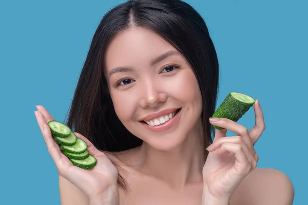 Le söt ung kvinna innehav löss av gurka och må bra — Stockfoto