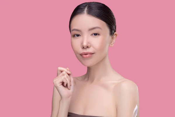 Menina asiática bonita com ombros nus olhando pensativo — Fotografia de Stock