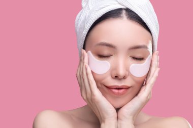 Beyaz başörtüsü takmış güzel Asyalı kız kendini rahat hissediyor.