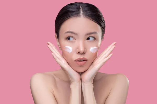 Ładna Azji dziewczyna stosując śmietanę na jej twarz — Zdjęcie stockowe