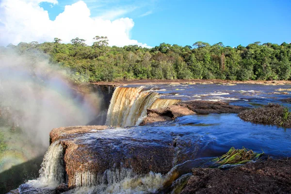 Güzel Kaieteur, açık bir güneşli günde, bulutlu mavi gökyüzünün arka planında Amazon ormanına düşer, Guyana. Dünya turizmi, eko-turizm, şelaleler.