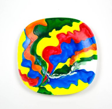 Yuvarlak köşeli kare şeklinde seramik tabaka beyaz arkaplan soyut deseninde izole edilmiş parlak renklerle boyanmış.