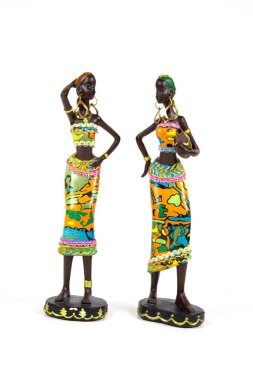 Beyaz arka planda izole edilmiş, parlak ulusal kostümlerle boyanmış iki Afro-Amerikalı kadının seramik figürleri. Hatıralar, Afrika motifi.