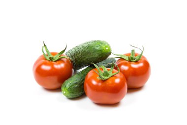 Beyaz bir zemin, yiyecek ve içeceklere izole edilmiş taze kırmızı domatesler ve yeşil salatalıklar. Sebzeler, faydalı ürünler, tarım.