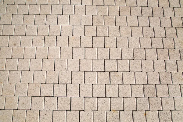 Güneşli bir günde kaldırımda güzel bir deseni olan gri yapay kare şeklindeki kaldırım taşlarının arkaplanı. Arkaplan, dokular, iç mekan.