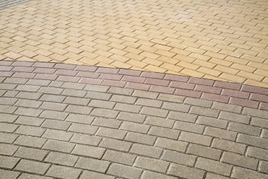 Açık güneşli bir günde, sarı leylak grisi bir yarım daire şeklinde, dikdörtgen kaldırım taşlarıyla döşenmiş kaldırım manzarası. Arkaplan, yapı, tasarım.