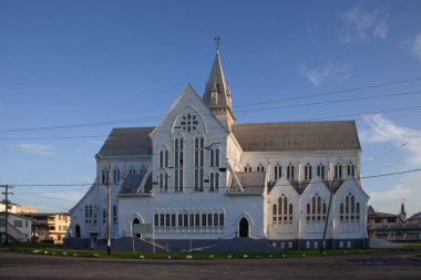 View of the old beautiful wooden building of St. George's Cathedral on a clear Sunny day against a background of blue sky and white clouds. Architecture landscape religion. clipart