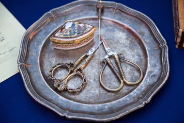 On dokuzuncu yüzyılın ortalarında metal bir plaka üzerinde tırnak makası saç tokası. Seçici odaklanma. Geçmiş ve şimdiki zaman.