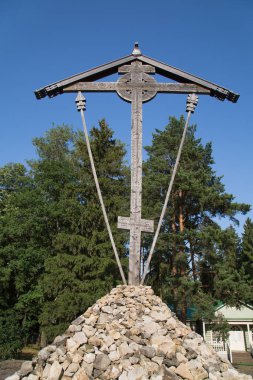 Güneşli bir günde, Moskova bölgesi, Rusya 'daki yüksek kaliteli çam ağacından yapılmış, taştan bir tepede Butovo haçı görülüyor..