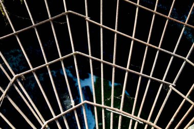 Metal takviyesinin açılışa karşı bir ağ şeklindeki görüntüsü, gün batımında güneş. Desen arkaplan tasarımı.