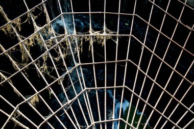 Metal takviyesinin açılışa karşı bir ağ şeklindeki görüntüsü, gün batımında güneş. Desen arkaplan tasarımı.