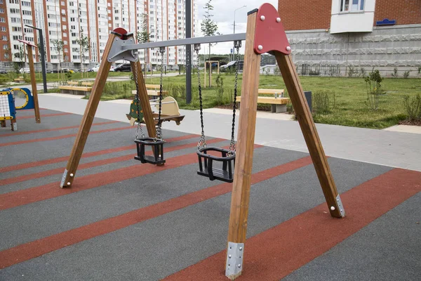 市内の屋外の遊び場で子供たちの木製のサポートをスイング スポーツは健康的なライフスタイル趣味です — ストック写真