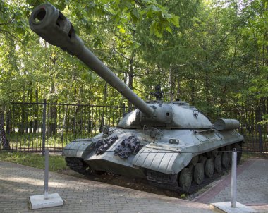 SSCB 'de yeşil ağaçların arka planında ağır bir tank var. İkinci Dünya Savaşı 'nın askeri teçhizatı..