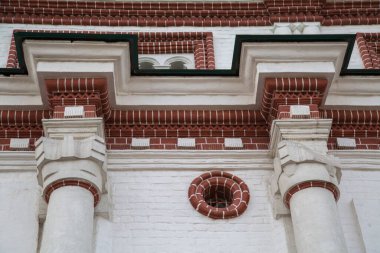 Eski bir ortaçağ binasının cephesindeki elementler, güzel dekoratif olarak tuğlayla kaplanmış. Mimari, elementler, orta çağın biçimi.