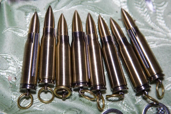 Charms in the form of cartridges metal brown. Military production, technology, industry.