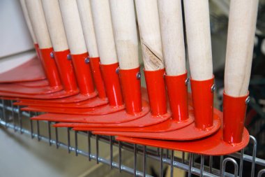 Ahşap kesiklerle sıralanmış parlak kırmızı çapalar. Tarım, tarım, kırsal araç.