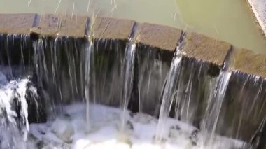 Göletten gelen su çitin beton duvarından aşağı dökülüyor. Doğa ekolojisi.