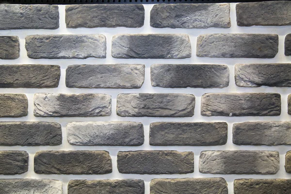 The background is made of artificial stone, white and black, with a rectangular shape in the form of a brick wall. Backgrounds, textures, and design.