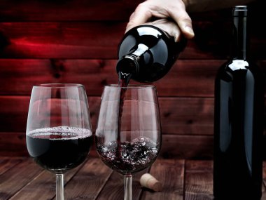 Kırmızı şarap döktü bir zarif kristal kadeh bir şişe üzerinde bir