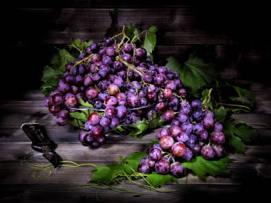 Eski bir ahşap masa üzerinde kırmızı üzüm demet.