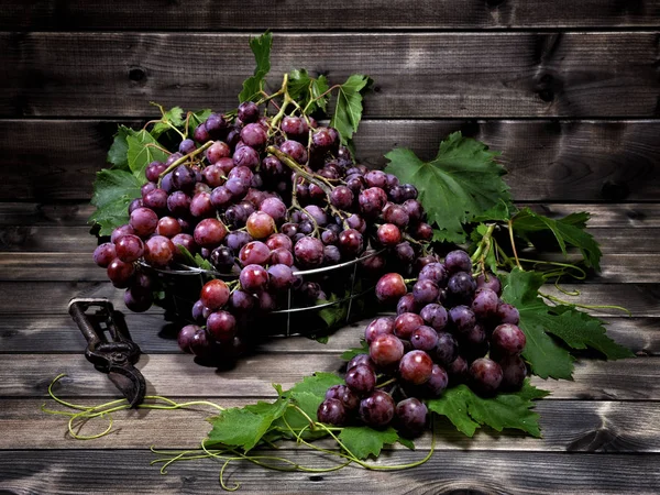 Eski bir ahşap masa üzerinde kırmızı üzüm demet.
