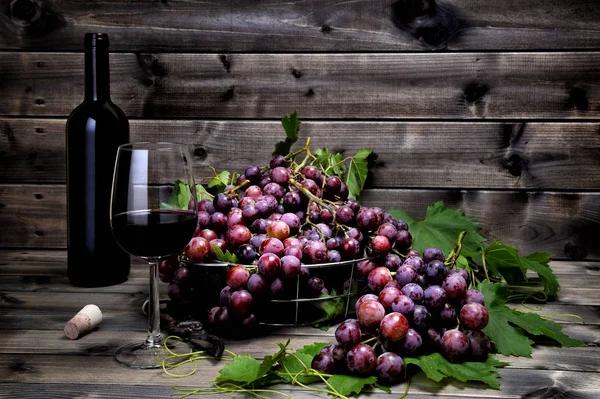 Pęczek czerwonych winogron na starym drewnianym stole. — Zdjęcie stockowe