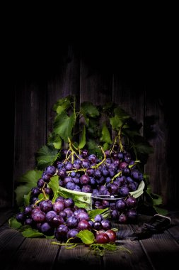 Eski bir ahşap masa üzerinde kırmızı üzüm demet.