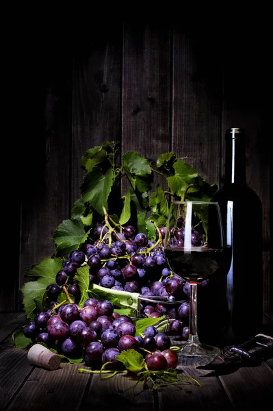 Pęczek czerwonych winogron na starym drewnianym stole. — Zdjęcie stockowe