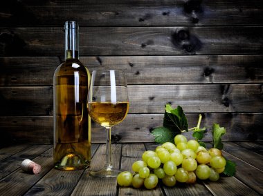 Şarap kadehi ve taze beyaz üzüm antika ahşap bac üzerinde demet