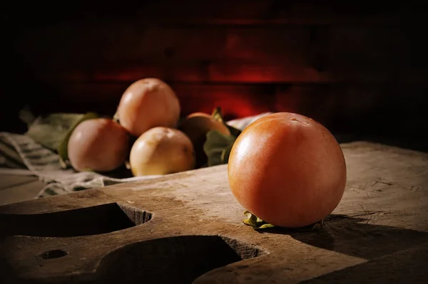 Persimmon segar baru saja dipetik di atas meja kayu tua — Stok Foto