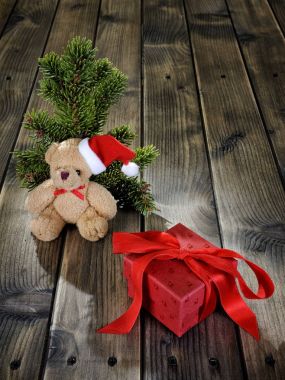 Oyuncak ayı ve Noel kutu ahşap arka plan üzerinde