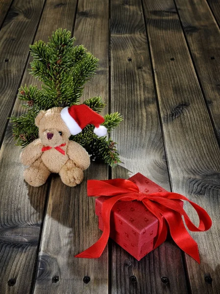 Urso de pelúcia e caixa de Natal no fundo de madeira — Fotografia de Stock