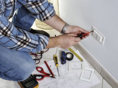 Bir konut elektrik sisteminde çalışan elektrikçi