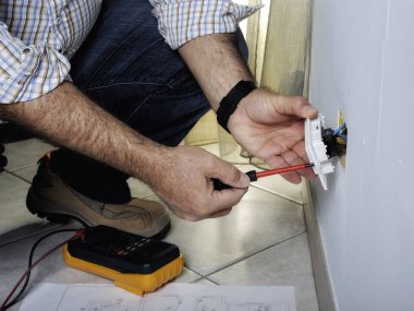 Bir konut elektrik sisteminde çalışan elektrikçi