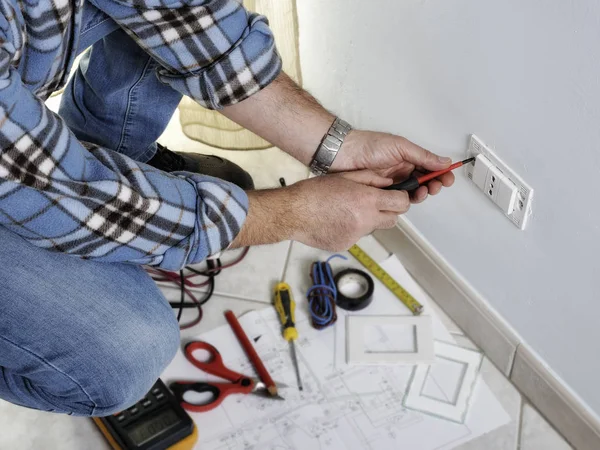 Eletricista trabalhando em um sistema elétrico residencial — Fotografia de Stock