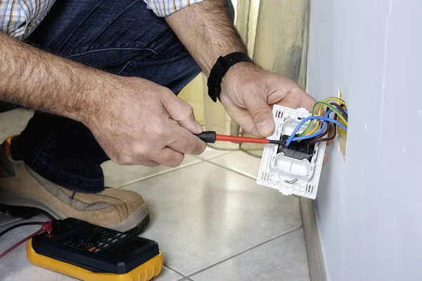 Electricista trabajando en un sistema eléctrico residencial — Foto de Stock